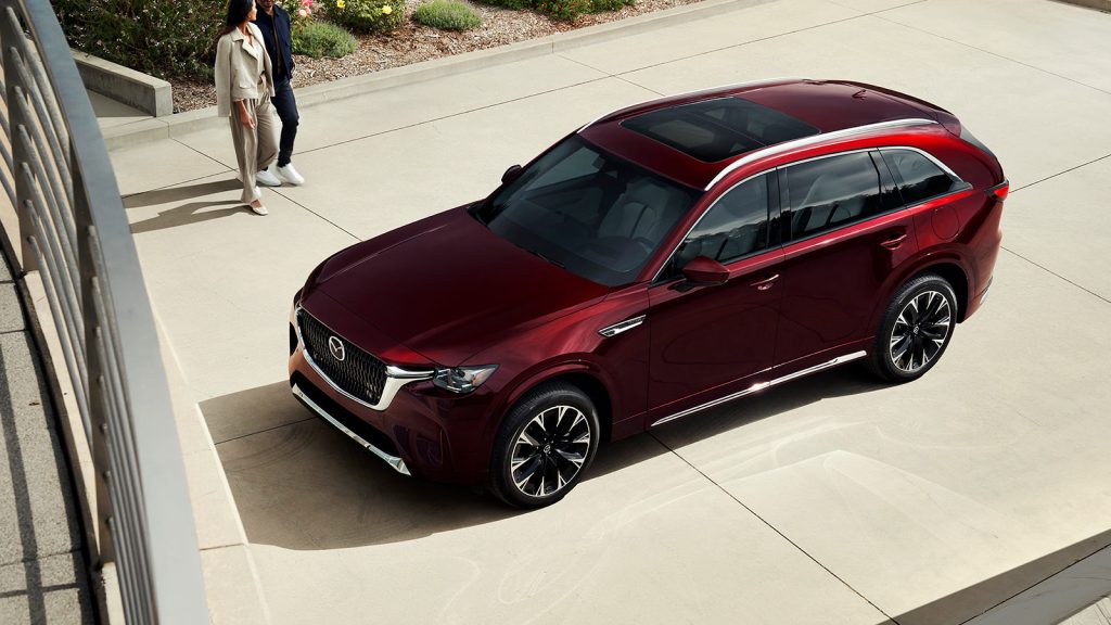 2026 Mazda CX-90, parked on a driveway with two people walking nearby.